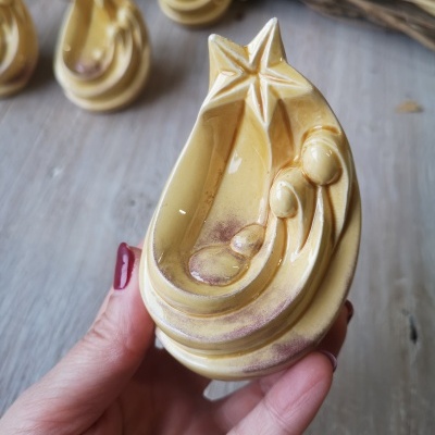 Peça decorativa em cerâmica amarela da Sagrada Família com estrela no topo