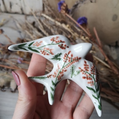 Figura em porcelana em forma de pássaro com padrão floral laranja e verde