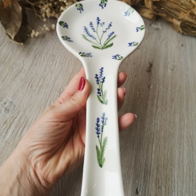 Colher de cerâmica branca decorada com flores azuis e folhas verdes