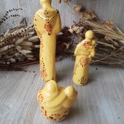 Três figuras decorativas amarelas em cerâmica com padrões florais