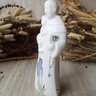 Estatueta de porcelana branca de santo com criança e flores azuis decorativas