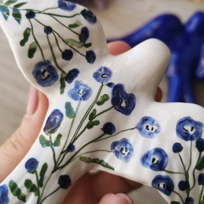 Pássaro decorativo cerâmico branco com flores azuis pintadas