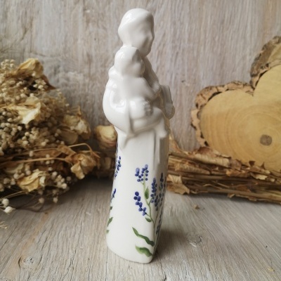 Figura em porcelana de Nossa Senhora com Menino e flores azuis sobre mesa de madeira