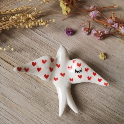 Pássaro decorativo branco com corações vermelhos e palavra Amor