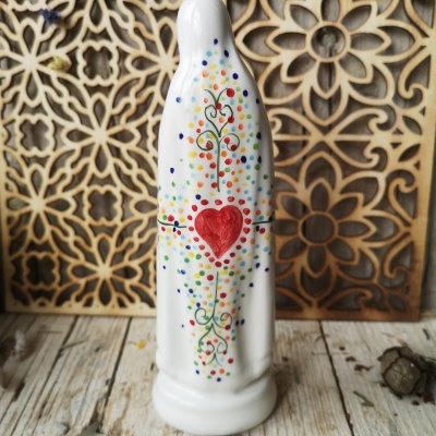 Figura religiosa branca com decoração colorida sobre madeira