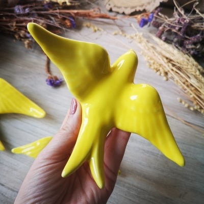 Escultura cerâmica de pássaro amarelo brilhante
