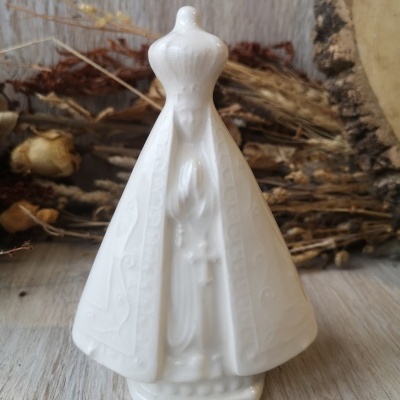 Estatueta branca em cerâmica de figura religiosa com capa detalhada