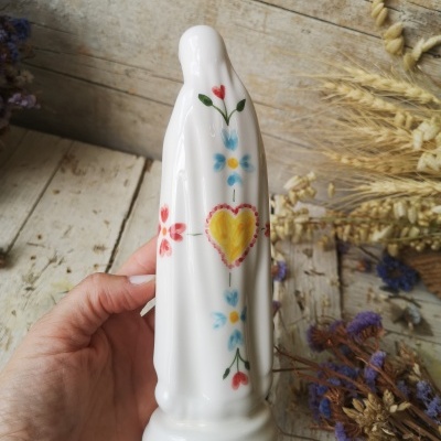 Estatueta branca em cerâmica com padrão colorido de coração e flores