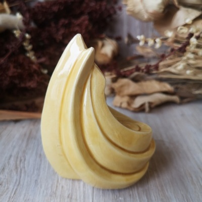 Anel amarelo curvo com flores secas ao fundo