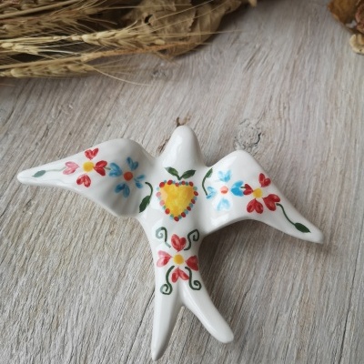 Pássaro decorativo em cerâmica branca com pintura floral colorida