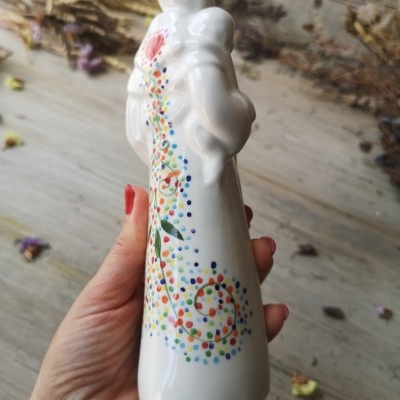 Figura decorativa em cerâmica branca com design colorido e bebé nos braços