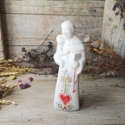 Figura de cerâmica branca de mãe com criança e decoração colorida de coração e flores