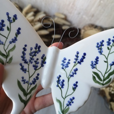 Borboleta decorativa em cerâmica com flores azuis e verdes