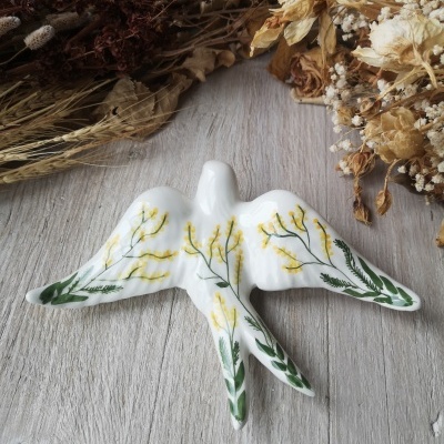 Estatueta pássaro cerâmica branca com flores amarelas e folhas verdes