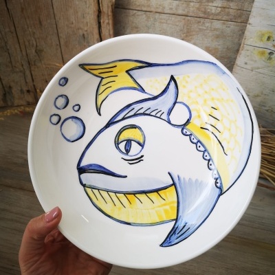Prato cerâmico branco com desenho colorido de peixe e bolhas