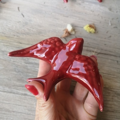 Estatueta de cerâmica vermelha em forma de ave