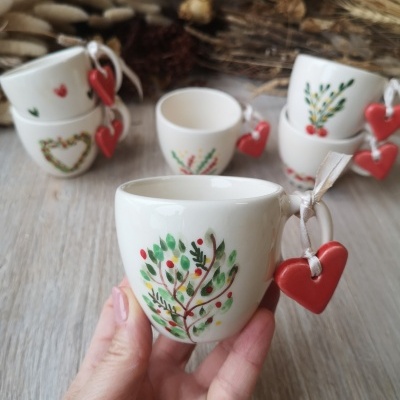Chávenas de cerâmica branca com desenhos de ramos verdes e corações vermelhos pendurados