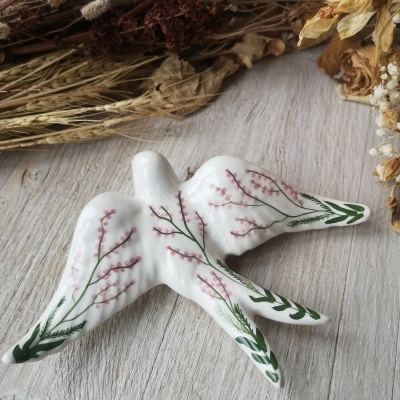 Pássaro decorativo em cerâmica branca com pintura floral