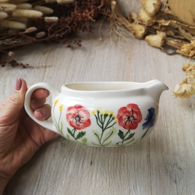 pequena leiteira de cerâmica branca com flores coloridas