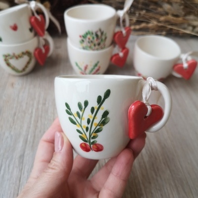 Pequenas chávenas de cerâmica branca com decorações florais e coração vermelho na pega
