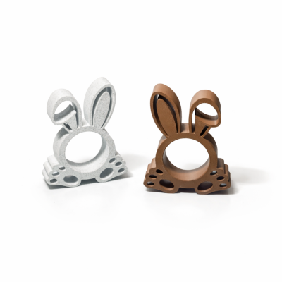 Dois suportes em forma de coelho, branco e castanho, sobre fundo branco