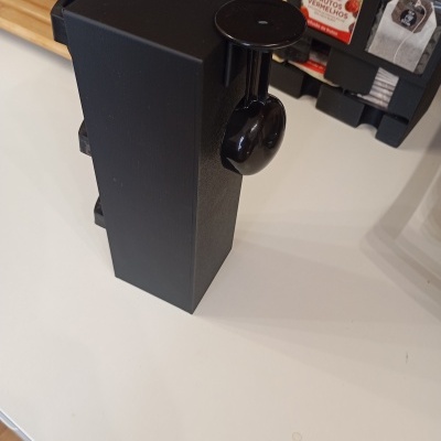 Dispositivo preto com suporte para auscultadores e embalagens de chá Tetley e CHAI ao fundo