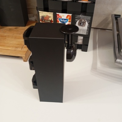 Organizador de chá e café preto com saquetas Tetley e Chai numa bancada branca