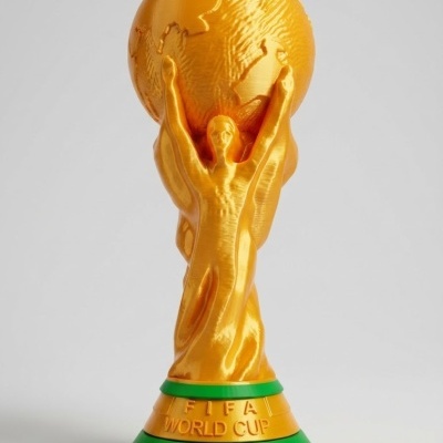 Estátua dourada da Taça do Mundo FIFA com base verde e inscrição