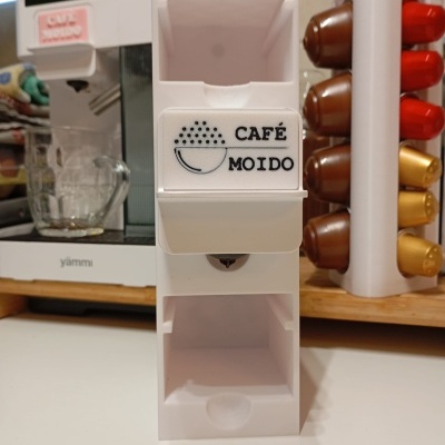 Doseador branco para cápsulas de café com etiqueta CAFÉ MOIDO em bancada de cozinha.