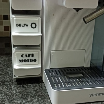 Máquina de café branca com suporte de cápsulas na bancada