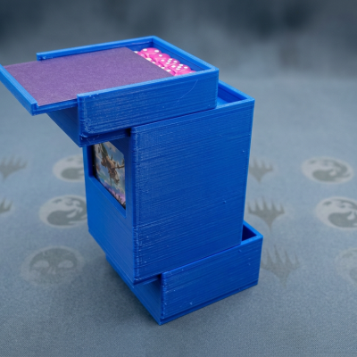 Estojo azul com dados e cartas de jogo em superfície com padrão de cartas