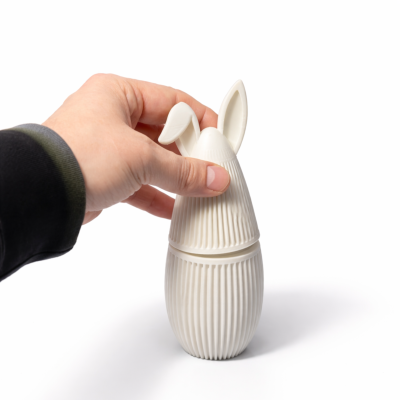 Recipiente branco em forma de coelho com textura de linhas verticais e orelhas detalhadas