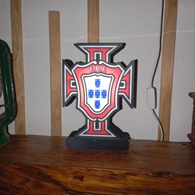 Figura decorativa em madeira com emblema da Federação Portuguesa de Futebol em cores preta, vermelha, branca e azul