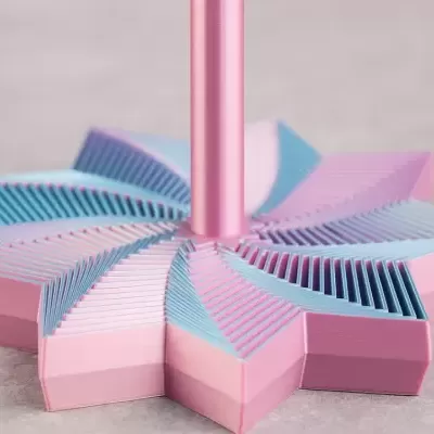 Base de suporte em forma de estrela com folhas cor-de-rosa e azul e cilindro cor-de-rosa no centro
