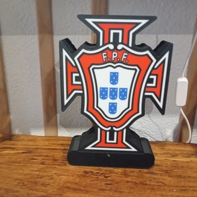 Estátua em plástico em forma de cruz vermelha com brasão da F.P.F. em fundo branco