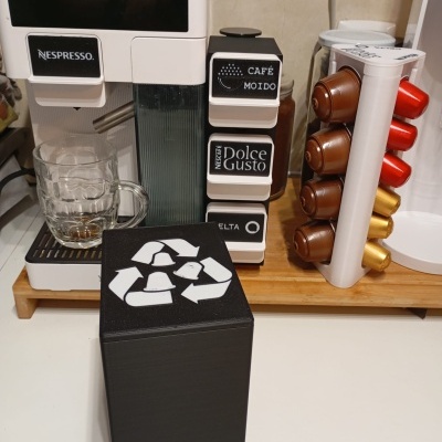 Máquina de café branca Nespresso com suporte de cápsulas e caixote de cápsulas usadas preto.