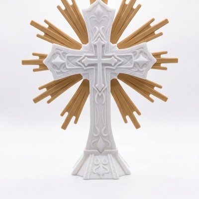 Cruz decorativa branca com detalhes em relevo e radiações douradas atrás.