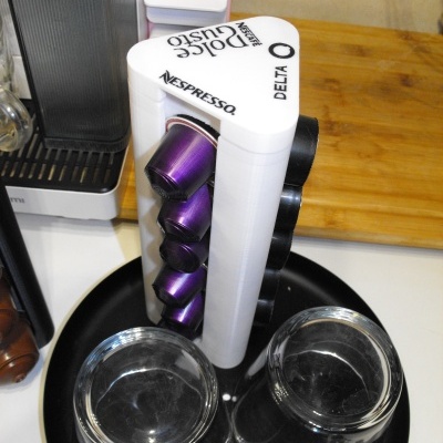 Suporte triangular branco para cápsulas Nespresso com chávenas de café em bandeja preta