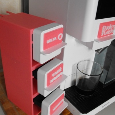 Máquina de café branca com suporte e cápsulas vermelhas