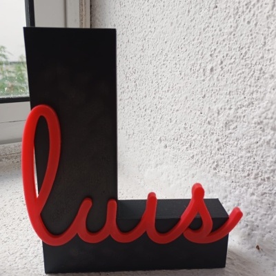 Escultura decorativa preta e vermelha com o nome luis.