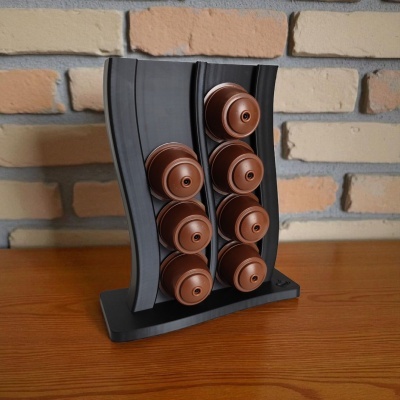 Suporte preto para cápsulas de café com cápsulas castanhas em superfície de madeira