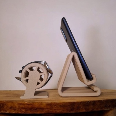 Suportes bege para relógio e telemóvel em mesa de madeira