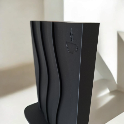 Suporte preto para livros com textura ondulada e ícone de chávena de café