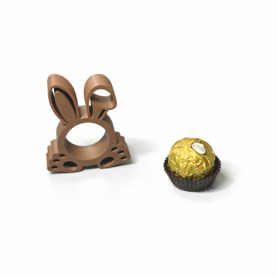 Anel de chocolate em forma de coelho e bombom Ferrero Rocher sobre fundo branco