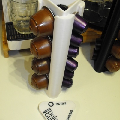 Suporte branco para cápsulas de café com cápsulas castanhas e roxas e separador branco com texto