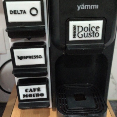 Máquina de café preta yämmi com suporte de cápsulas branco com etiquetas DELTA Q, NESPRESSO, CAFÉ MOÍDO