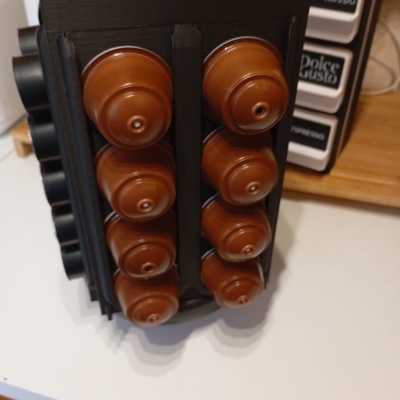 Suporte giratório preto com cápsulas de café marrons em cozinha