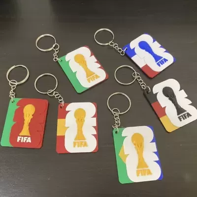 Porta-chaves FIFA coloridos em plástico sobre superfície escura
