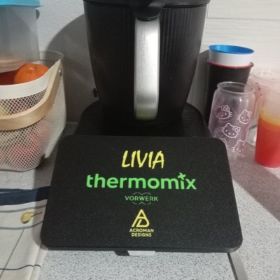 Tampa preta personalizada para Thermomix com nome LIVIA e logos em bancada de cozinha.