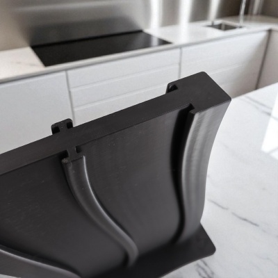 Peça estrutural preta de plástico com design curvo numa cozinha moderna
